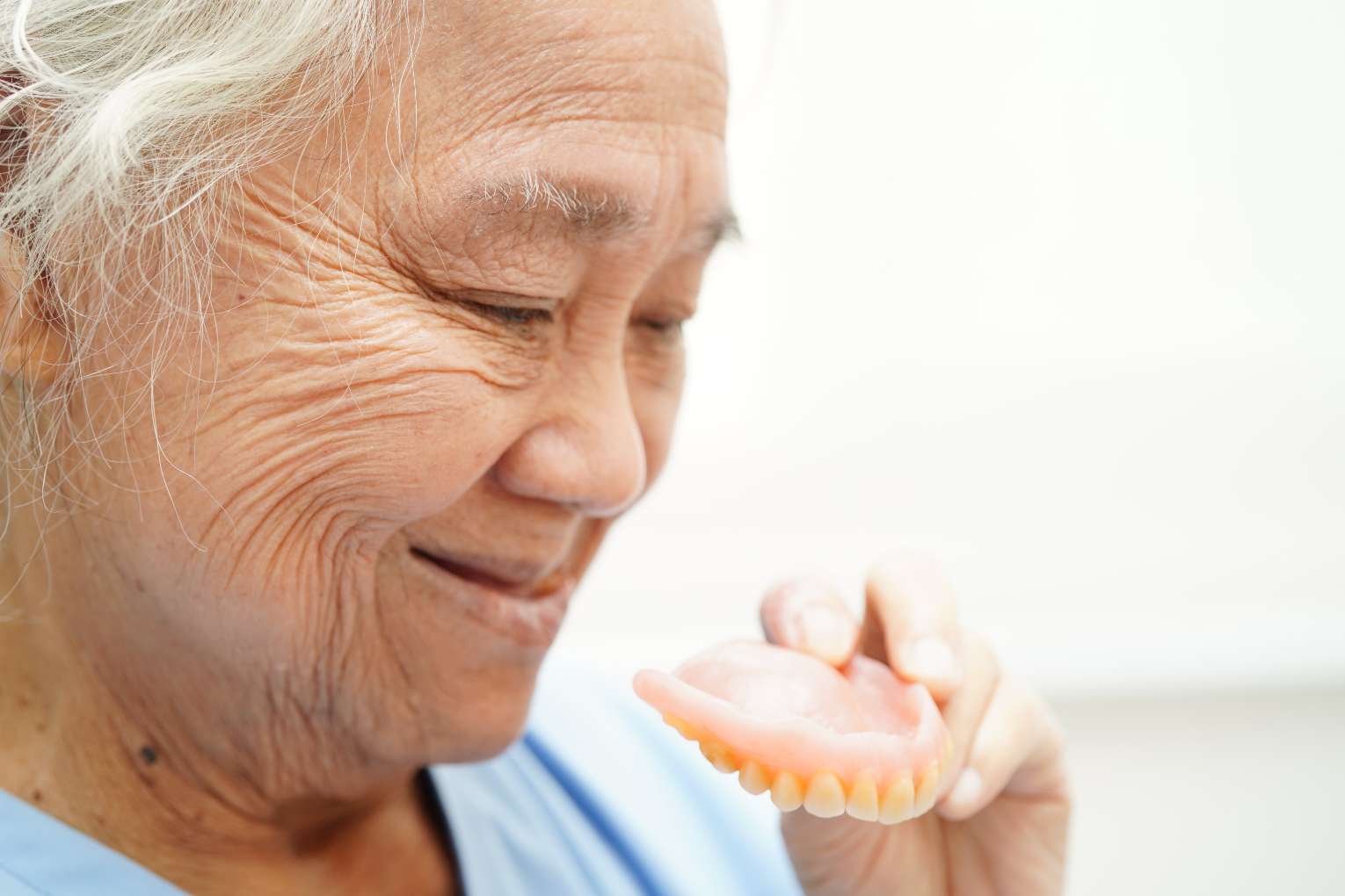 asian-senior-woman-patient-holding-teeth-denture-her-hand-chew-food 노인이 틀니를 들고있다
