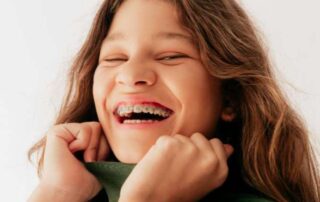 교정 치료 중에도 자신감 있게 활짝 웃는 행복한 성장기 청소년 환자