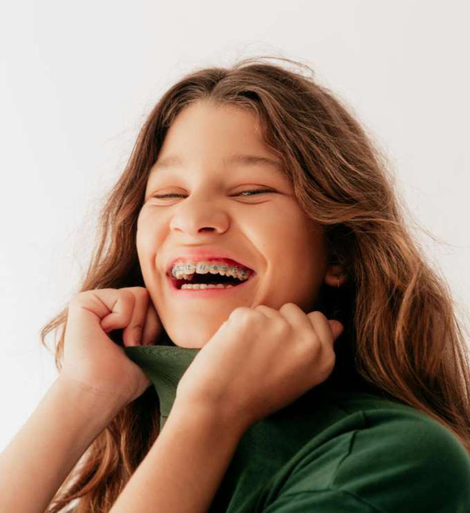 교정 치료 중에도 자신감 있게 활짝 웃는 행복한 성장기 청소년 환자